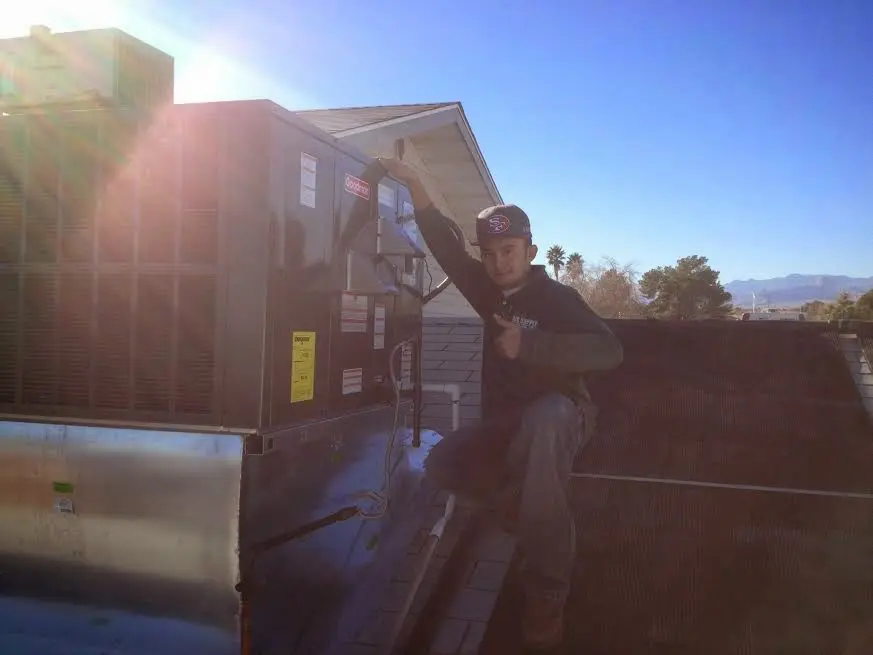 HVAC technician performing HVAC Inspection on a rooftop unit in Fresno